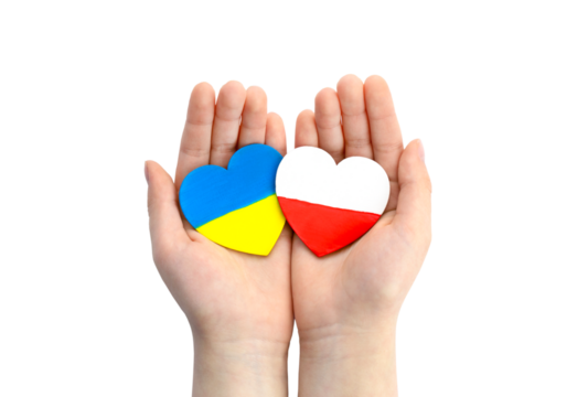 Children's hands hold two hearts with flags of Ukraine and Poland. Unity solidarity help concept	