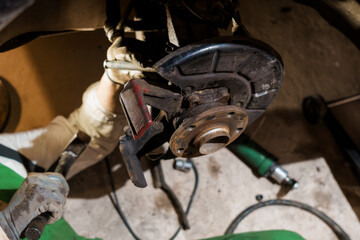 Automotive Technician Working on Brake Assembly in Garage