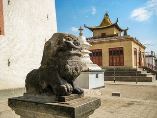 Obraz premium A stone statue of a dragon is sitting on a pedestal in front of a building