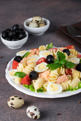 Canned salmon salad with pasta, cherry tomatoes, quail eggs, basil and black olives