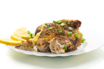 Fish with herbs and lemon on a plate, isolated on white background