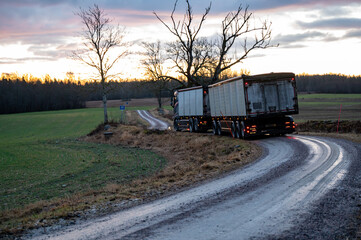 Truck with trailer on narrow wet and soft gravel road