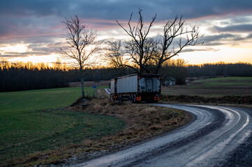 Truck with trailer on narrow wet and soft gravel road