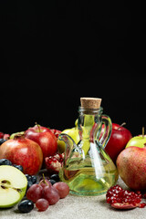 Vinegar in glass vinegar bowl cruet on black background among fruits