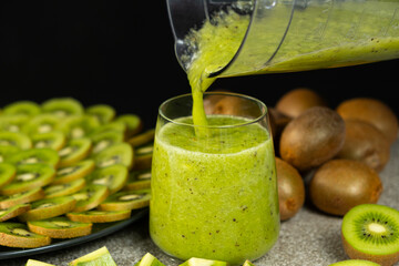 Fresh green kiwi smoothie pour from blender bowl into glass