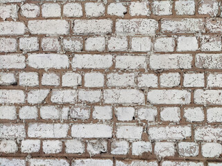 Textured white brick wall with distressed finish, ideal for backgrounds and design projects