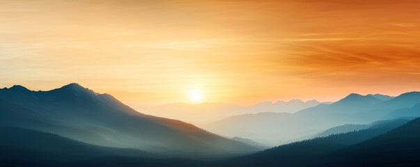 Obraz premium A serene sunset over misty mountains, showcasing vibrant orange and blue hues blending in the sky.