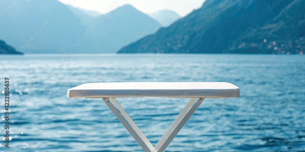 Poster elegant folding table by serene blue waters and mountains offering inviting copy space for text and 