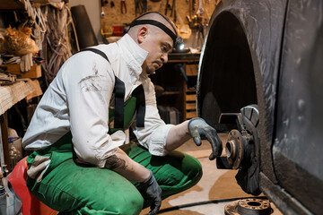Mechanic Working on a Car Wheel in a Workshop