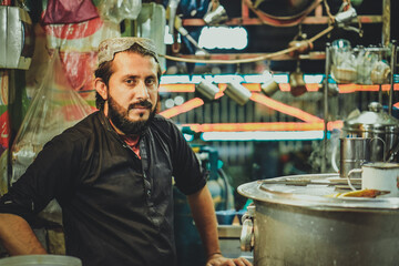 Portrait of young Pakistani Afghan Pathan man street vendor in his roadside chai tea stall