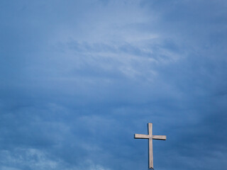 Christian Cross and Cloudy Sky Background with Copy Space