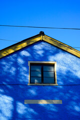 Casa de pueblo azul y  amarilla en día soleado