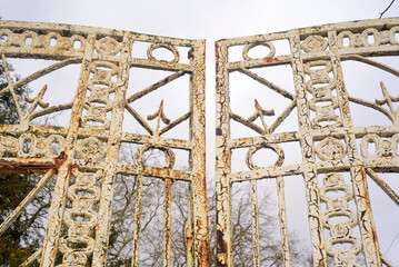 Motivos geométricos en puerta metálica oxidada en jardín de mansión