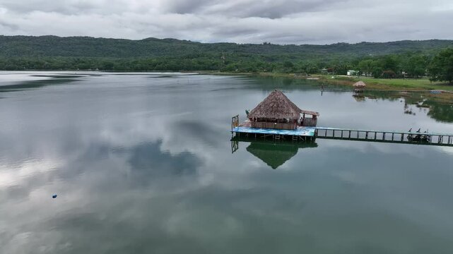 Lake Peten Itza in Guatemala, with a thatched hut perched on a platform extending over calm