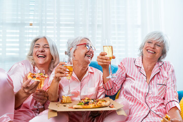 Beautiful senior women having funny pajama party at home - Group of cheerful elderly female friends...