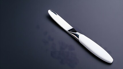 Elegant White Knife Resting on a Dark Surface with Reflection