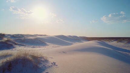 White sand dunes under a bright sky with few clouds and soft lighting creating gentle shadows