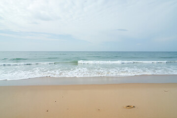 Sandy beach with gentle waves at sunset