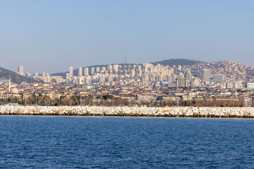 Fototapeta premium Skyline of Istanbul’s Asian side with modern residential buildings and a rocky shoreline. A vibrant view of the Anatolian side blending urban development and coastal beauty. Panaromic Istanbul 2025