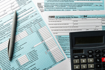 Federal income tax return preparation with 1040 form and calculator for filing season