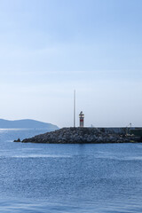 Breakwater lighthouse and calm harbor water at sunrise, coastal Turkey