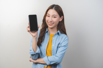 Naklejka premium Portrait of face expression smiling charming brunette, happy asian young woman hand holding, showing smartphone cell phone, mobile application in social network online on communication of technology.