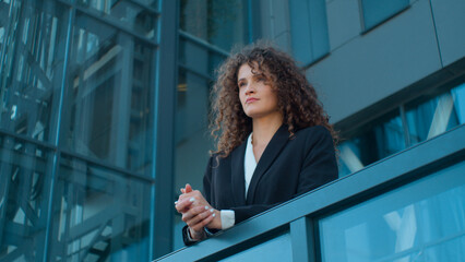 Fototapeta premium Pensive business girl lady on terrace balcony of office looking away thinking young businesswoman leader employer female manager director successful Caucasian woman think dream posing in city outdoors