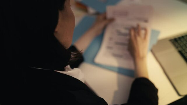 Woman detective reads confidential files, piecing together clues to solve a case