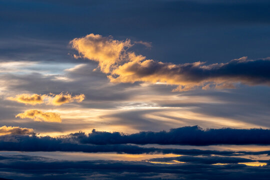 The sky is painted with vibrant hues during sunset, showcasing dramatic clouds and a blend of warm colors, creating a stunning and visually captivating spectacle.