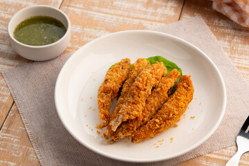 Deep fried Capelin Fish (Shishamo),Thai fried battered egg fish in white plate.snack food served with seafood sauce.