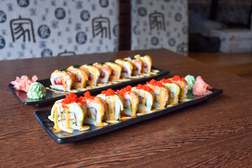 Colorful sushi set with rice. Garnish with pickled ginger and wasabi. Rolled sushi with avocado, mushrooms, tuna, salmon and sesame. With red caviar. Japanese food