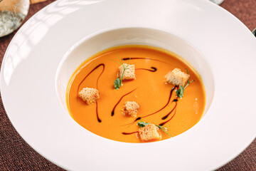 Portion of gourmet pumpkin cream soup with croutons 