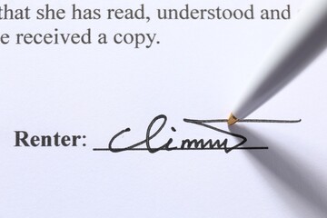 Pen leaving signature on contract, closeup view