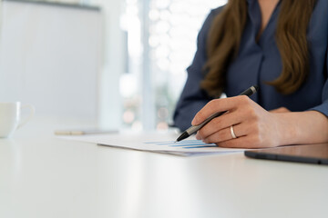 Businesswoman sitting at desk on couch in workplace or at home working on laptop and analyzing data...