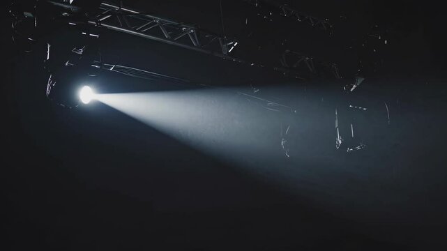 Bright spotlight shines down in a dark venue during a captivating performance