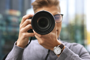 Professional photographer taking picture with camera outdoors, selective focus