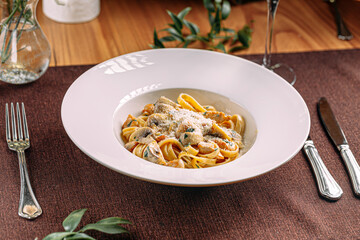 Portion of fettuccine alfredo pasta with mushrooms and chicken