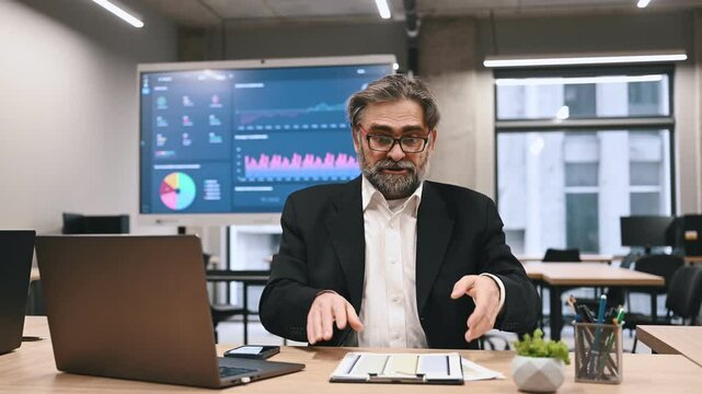 Angry dissatisfied businessman in a formal suit arguing sitting at workplace in business office. Excited man boss talks with subordinate about problems