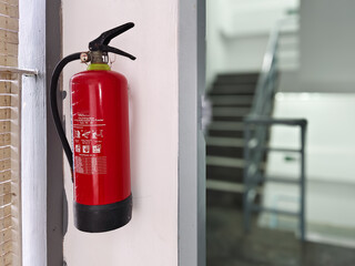 light fire extinguisher or APAR with a background of emergency stairs in the building