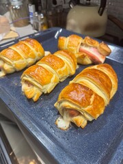 Sausage in dough on a baking sheet in the kitchen