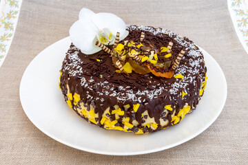 Delicious chocolate cake topped with decorative elements and fresh flowers