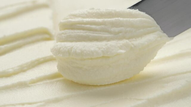 Close-up knife scooping natural cream cheese from package, concept video