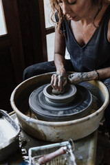 Fototapeta premium latin woman working with clay pot in workshop and entrepreneurship ceramic business in art in Mexico Latin America