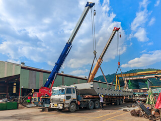 A Mobile Crane Lifts a Barge onto a Trailer for Transport from the Fabrication Shop to the River.