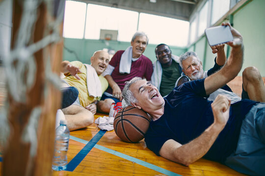 Senior men taking group selfie after basketball game