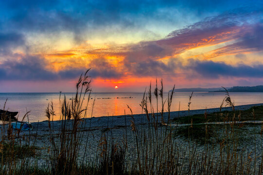 small bay with sunset and dramatic sky