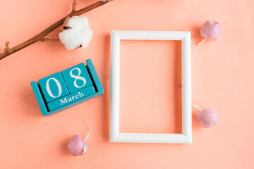 March 8. Blue cube calendar with month and date and mockup photo frame on pink pastel background.