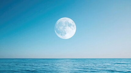Full moon over tranquil ocean at night; serene seascape for travel brochures