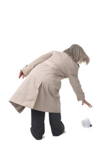 back view of a woman picking up a plastic water bottle on the floor on white background