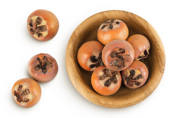 Brown fresh medlars in a wooden bowl isolated on white background. Mespilus germanica . Top view. Flat lay
